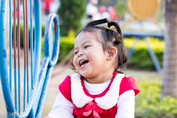 Cute little girl is playing slide on playground