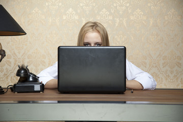 business woman hiding behind a laptop - obrazy, fototapety, plakaty