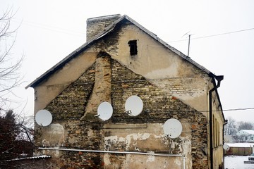 Satellite dish on the wall of a old house