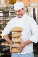 Smiling baker holding fresh loaves