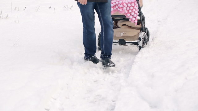 Parents with a Stroller on Snowy Road