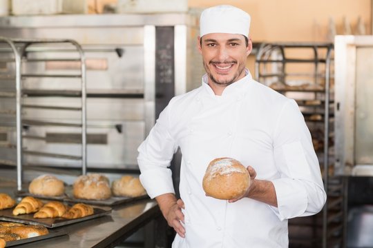 Baker holding a freshly baked loaf