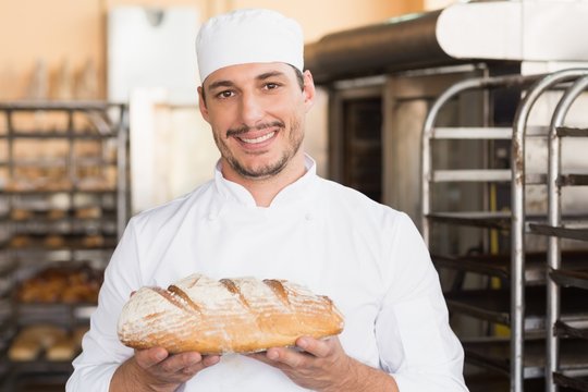 Baker holding freshly baked loaf