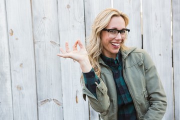 Happy blonde in glasses making okay gesture