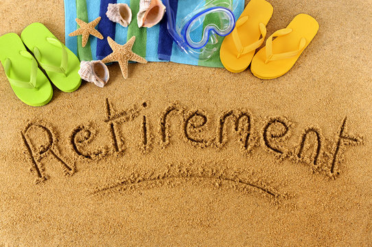 The word Retirement written in sand on a beach with towel flip flops and seashells old age summer holiday vacation photo