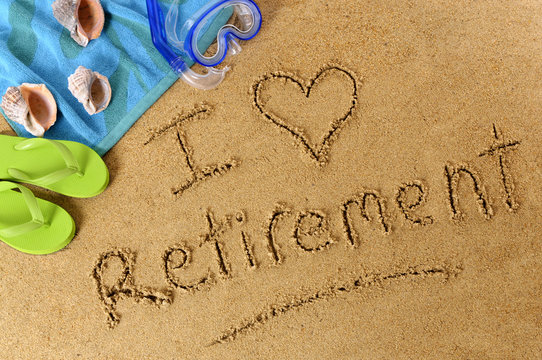 The word I Love Retirement written in sand on a beach with towel flip flops and seashells old age summer holiday vacation photo