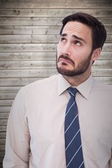 Composite image of portrait of a nervous businessman looking up