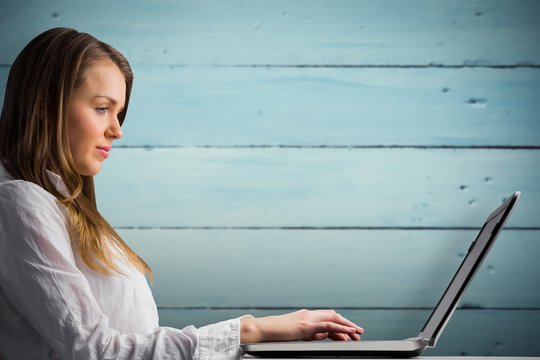 Composite image of businesswoman typing on her laptop