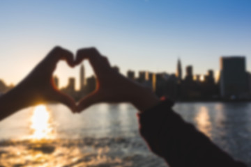 Heart Shaped Hands with New York Skyline. Blurred Background.