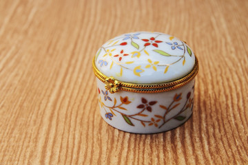 round jewelry box on wooden bg