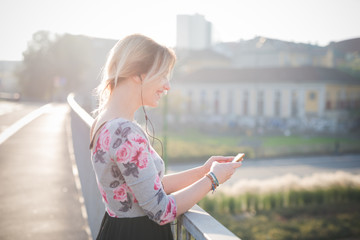 young beautiful blonde woman outdoor listening music