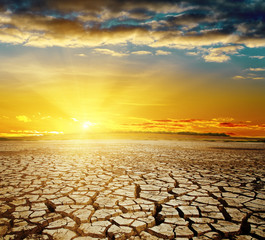 global warming. dramatic sunset over cracked earth