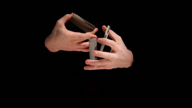 Magic card trick known as kardistri on black background, slow