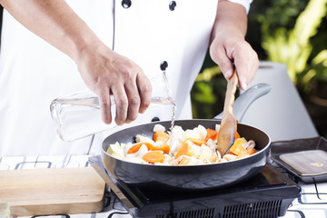 Chef pouring soup to the pan for cooking Japanese pork curry