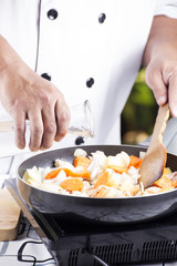 Chef pouring soup to the pan for cooking Japanese pork curry