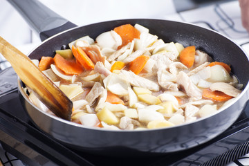Chef putting vegetable to the pan for cooking Japanes pork curry