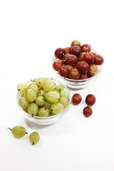 Rote und grüne Stachelbeeren in Glasschälchen