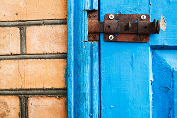 closed metal latch on blue painted woooden door