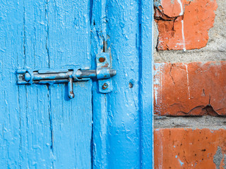 Espagnolette on old blue painted door of shed