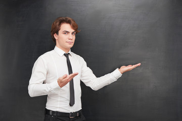 Casual man pointing at blank chalkboard