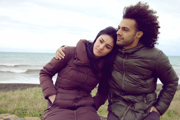 Retro style of couple hugging on the beach in winter