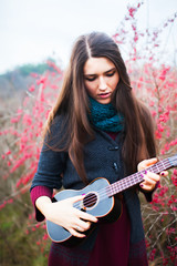 Fototapeta na wymiar young beautiful woman playing guitar