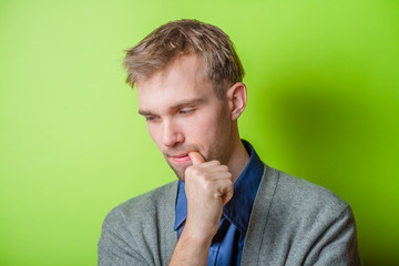 Closeup portrait of thinking man with finger in mouth, sucking thumb, biting fingernail in anxiety, stress, deep in thought. Negative emotion, facial expression, feelings