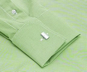 Fototapeta na wymiar The green sleeve of a plaid shirt with a cuff link