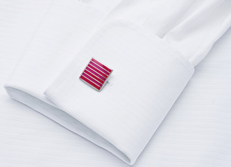 Sleeve of a white shirt with a red cuff link