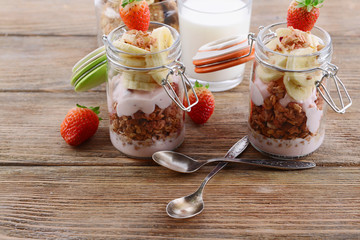 Healthy layered dessert with muesli and berries on table