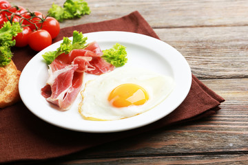 Bacon and eggs on rustic wooden planks background
