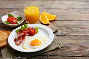 Bacon and eggs on rustic wooden planks background