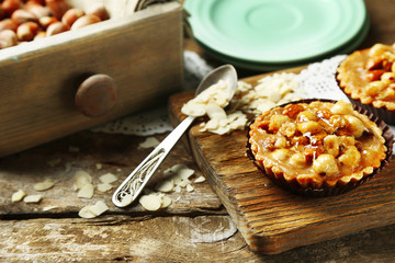 Mini cakes with nuts on wooden background