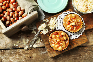 Mini cakes with nuts on wooden background