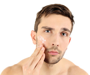 Obraz premium Handsome young man applying cream lotion