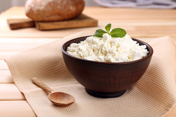 Cottage cheese in bowl with bread on table close up