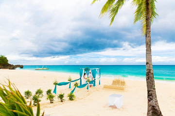 Obraz na płótnie Canvas Wedding ceremony on a tropical beach in blue. Happy groom and br