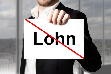Geschäftsmann hält Schild Lohn durchgestrichen Lohnkürzung