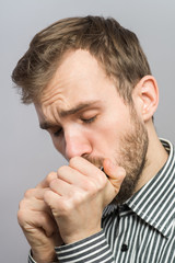 Full face portrait of man playing harmonica on gray background