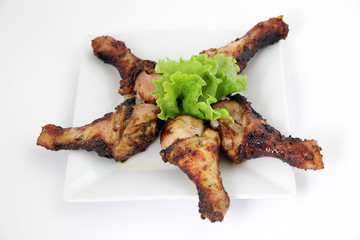Grilled chicken legs (drumsticks) on white plate