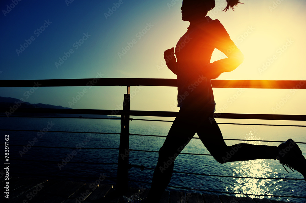 Poster young fitness woman running on sunrise seaside boardwalk