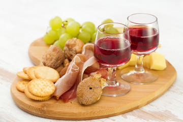 red wine with dry fruits, cookies and cheese