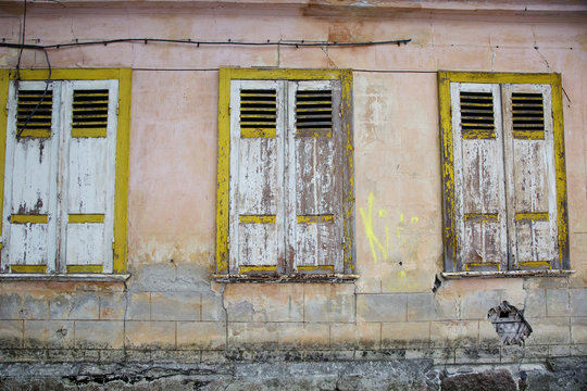 The three windows of old house with shutters