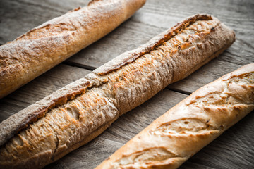 Three baguettes on the wooden background
