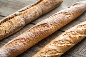 Three baguettes on the wooden background