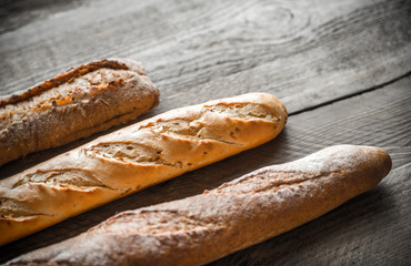 Three baguettes on the wooden background
