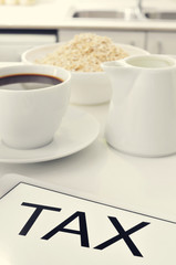 tax written in the screen of a tablet, on a set table for breakf