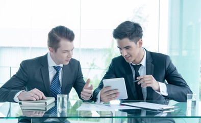 Two businessman using tablet in meeting