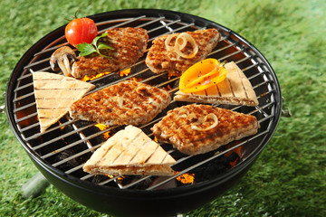 Chicken fillets and bread grilling on a BBQ