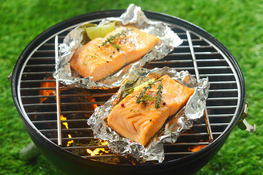 Two gourmet salmon cutlets grilling on a fire